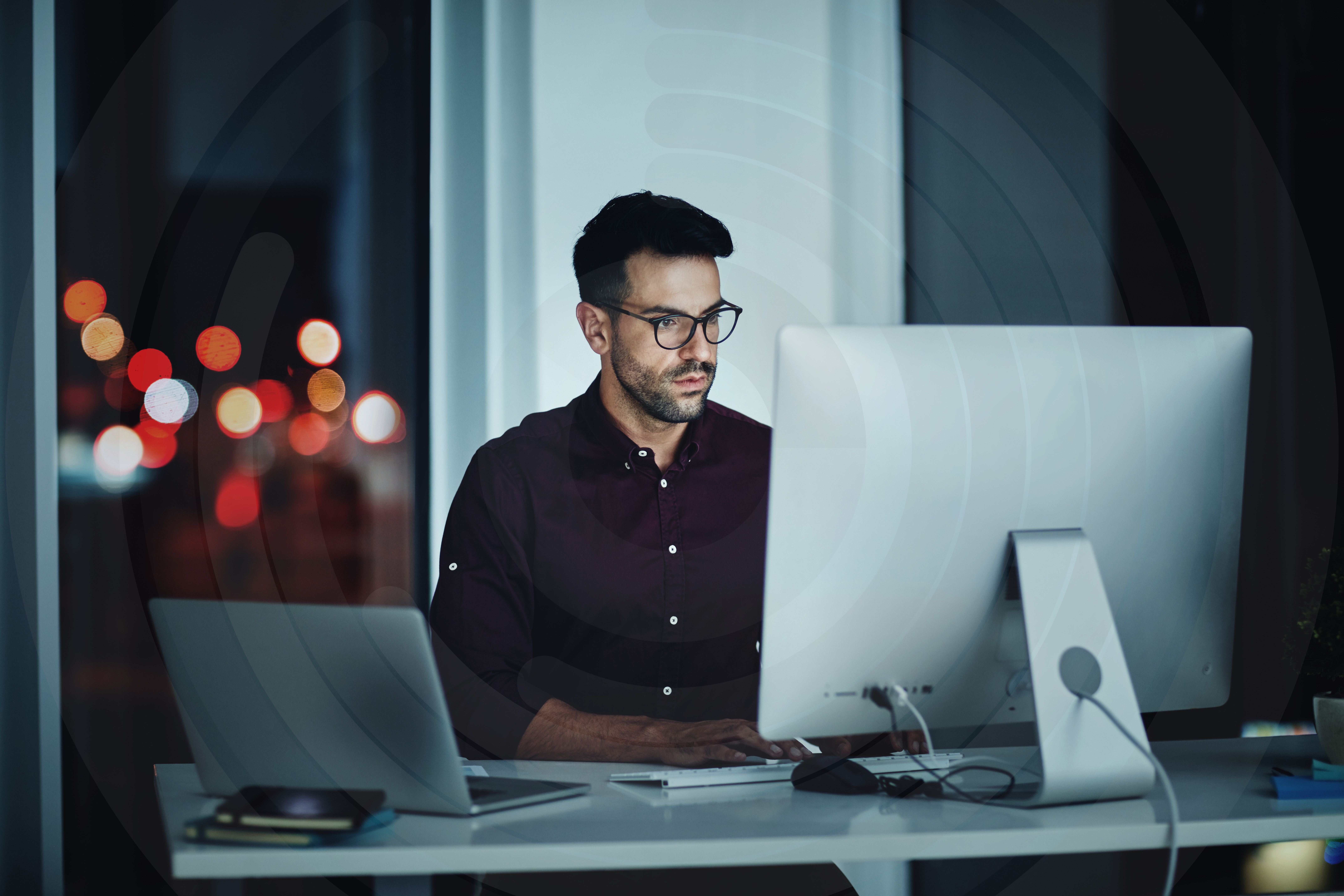 Man with glasses at desktop computer at night insider risk management